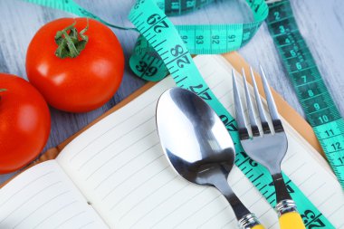 kaset ve kitap sebze ile ahşap zemin üzerinde ölçüm ile bağlı çatal bıçak takımı