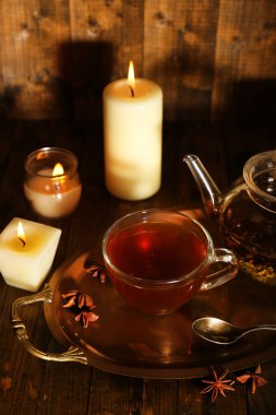 Çay Kupası ve çaydanlık ve tablo, ahşap arka plan üzerinde mum ile kompozisyon