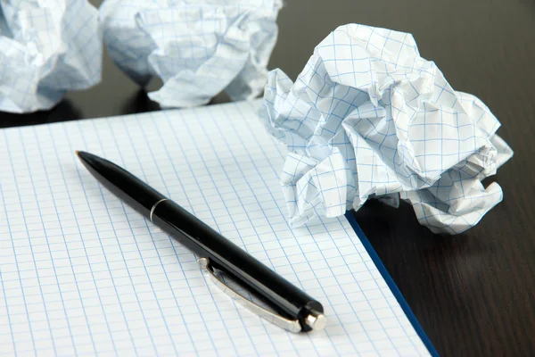 Pelotas de papel arrugadas con cuaderno y pluma sobre fondo de madera — Foto de Stock