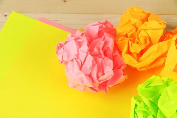 Ahşap arka plan üzerinde renkli buruşuk kağıt topları — Stok fotoğraf