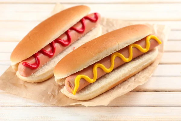 Pyszne hot dogi na drewnianym stole — Zdjęcie stockowe