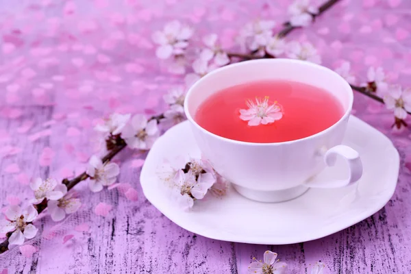 Çiçekli dallar üzerinde ahşap masa yakın çekim güzel kokulu çay — Stok fotoğraf