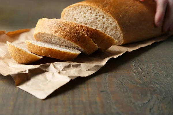 Female hands cutting bread on wooden board, close-up — Stock Photo, Image