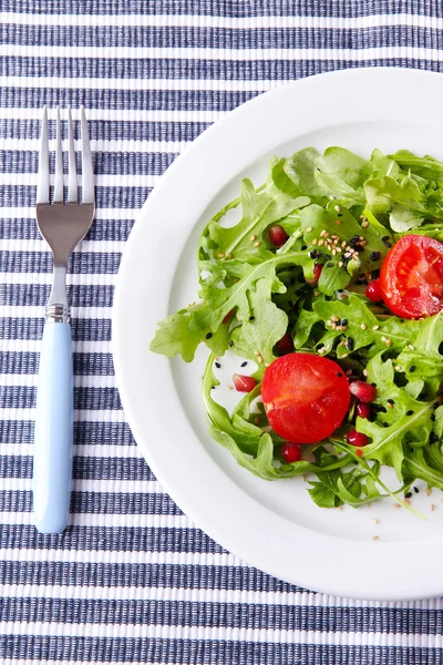 Ensalada verde elaborada con rúcula, tomate y sésamo sobre plato, sobre fondo de madera —  Fotos de Stock