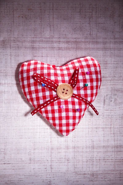 Ύφασμα καρδιάς με καρφίτσες χρώμα σε ξύλινα φόντο — Φωτογραφία Αρχείου