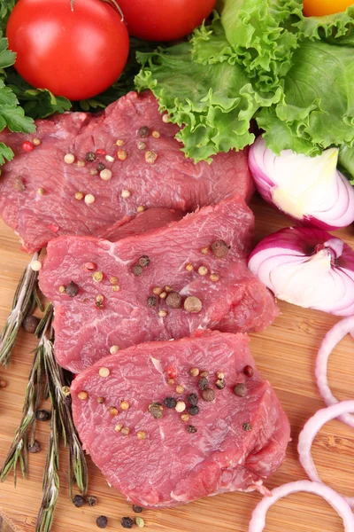 Raw beef meat with vegetables on table close up — Stock Photo, Image