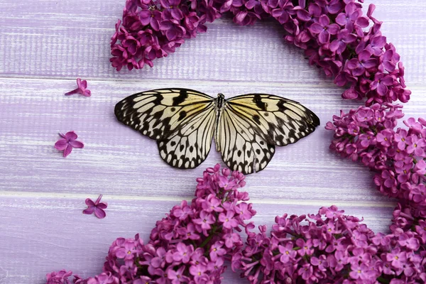 Beautiful butterfly and lilac flowers, on wooden background — Stock Photo, Image