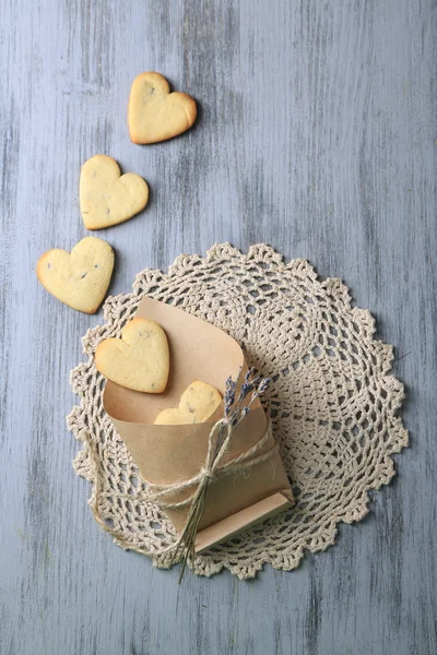 Lavender cookies in paper bag, on color wooden background — Stock Photo, Image