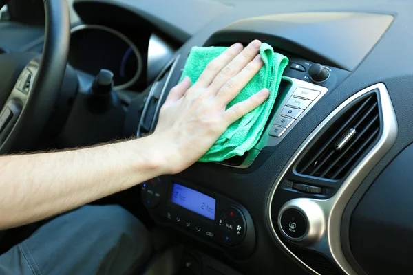 Hand with microfiber cloth polishing car