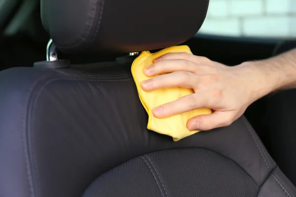 Hand with microfiber cloth polishing car