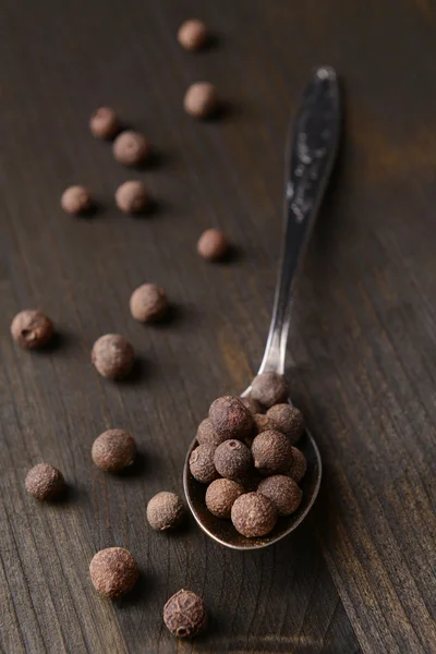 Pimienta de especias en cuchara sobre fondo de madera — Foto de Stock