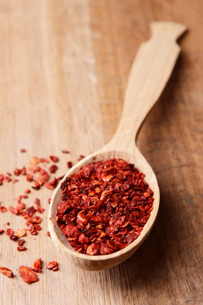 Spice pepper in spoon on wooden background — Stock Photo, Image