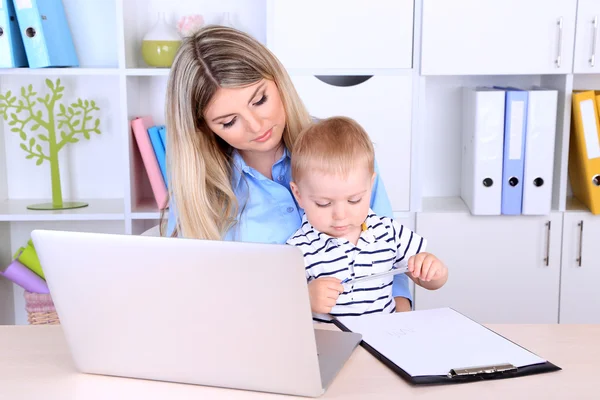 Mujer bonita con bebé trabajando en casa — Foto de Stock