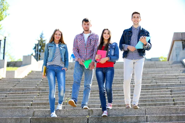 Gelukkig studenten op trappen in het park — Stockfoto