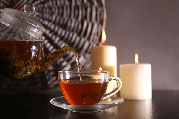 Tea pouring into glass cup on dark background — Stock Photo, Image