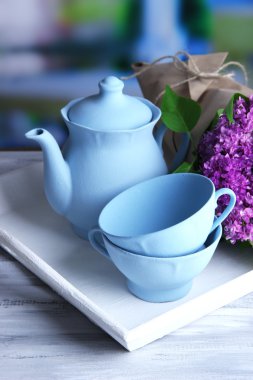 Çay seti ve parlak zemin üzerine ahşap masa üstünde tepsi üzerinde güzel bahar buket kompozisyonu