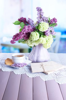 çay, eski mektup ve güzel bahar çiçek vazosu parlak zemin üzerine ahşap masa üzerinde cup ile kompozisyon