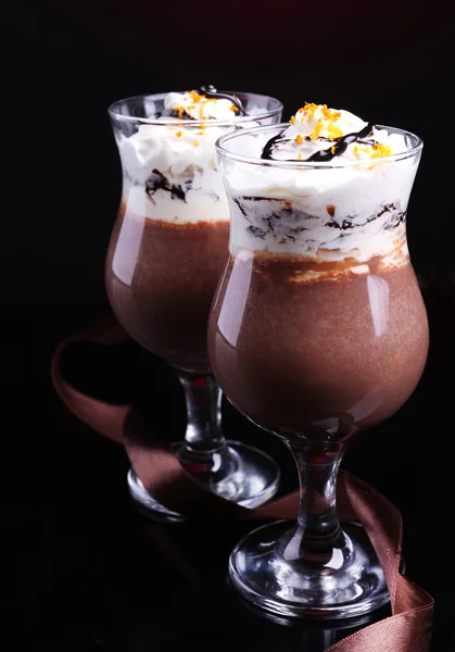 Sobremesa saborosa com chocolate, creme e molho de laranja, no fundo de cor escura — Fotografia de Stock