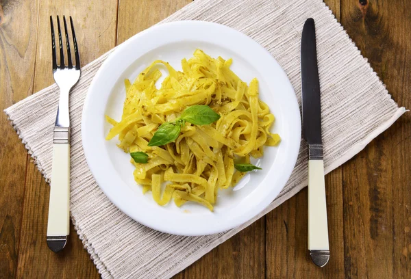 Deliciosa pasta con pesto en plato en primer plano de la mesa — Foto de Stock