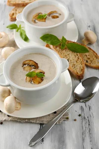 Mushroom soup in white pots, on napkin, on wooden background — Stock Photo, Image