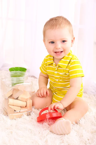 Milý chlapeček s dřevěnou hračkou blokuje v pokoji — Stock fotografie