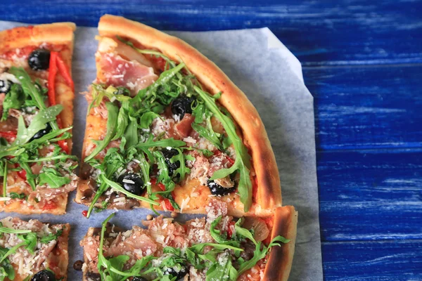 Pizza met rucola op een houten achtergrond kleur — Stockfoto