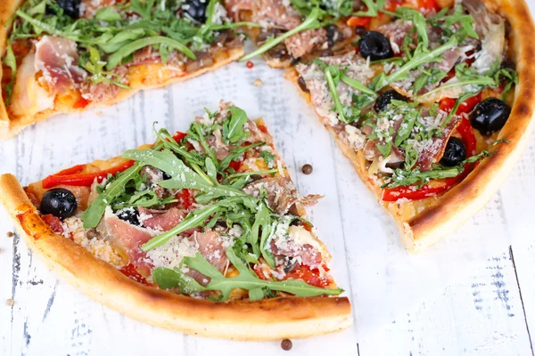 Pizza met rucola op een houten achtergrond kleur — Stockfoto