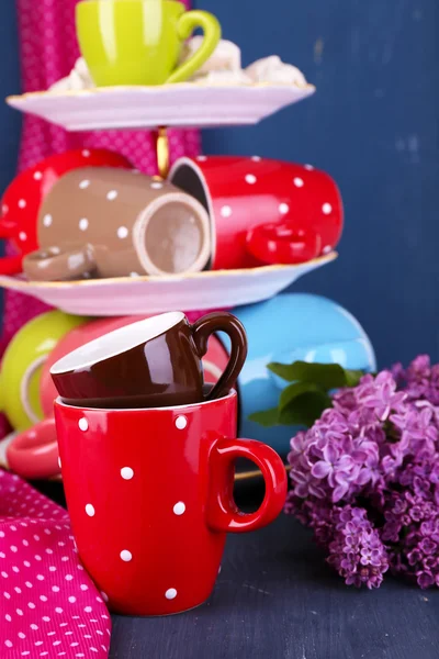 Cups in vase on table on wooden background — Stock Photo, Image