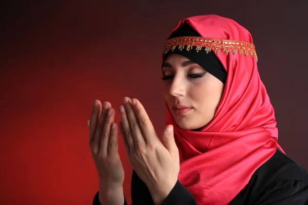 Mulher árabe muçulmana bonita orando em fundo de cor escura — Fotografia de Stock