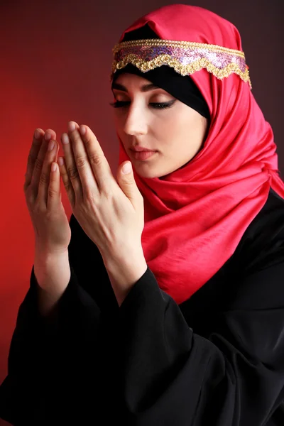 Beautiful muslim arabic woman praying on dark color background — Stock Photo, Image