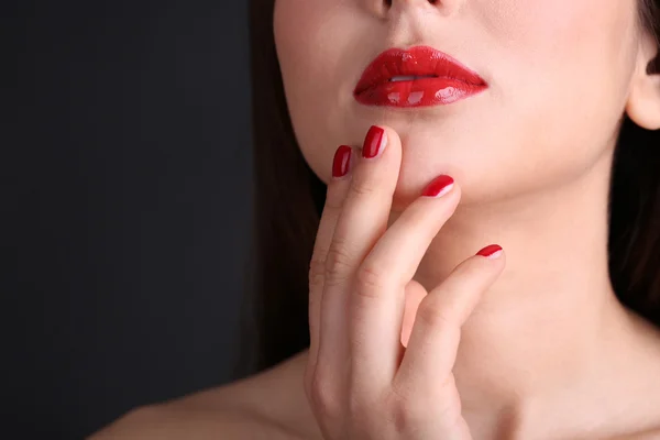 Menina com lábios vermelhos e unhas no fundo escuro — Fotografia de Stock