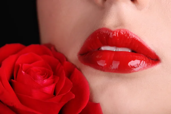 Girl with red lips and rose on dark background — Stock Photo, Image