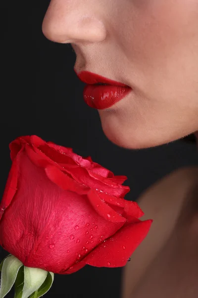 Lány vörös ajkak és Rózsa-sötét háttér — Stock Fotó
