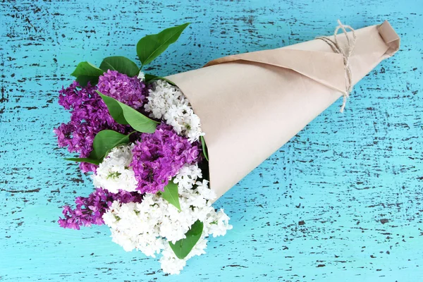 Красивий букет з бузкових квітів на кольоровому дерев'яному фоні — стокове фото