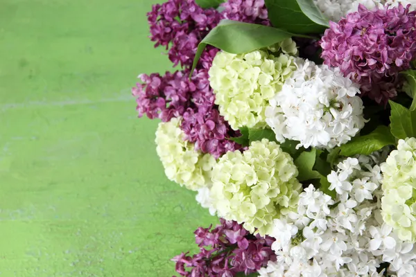 Beautiful bouquet of spring flowers on color wooden background — Stock Photo, Image