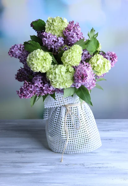 Bellissimi fiori primaverili in vaso, su tavolo di legno, su sfondo luminoso — Foto Stock