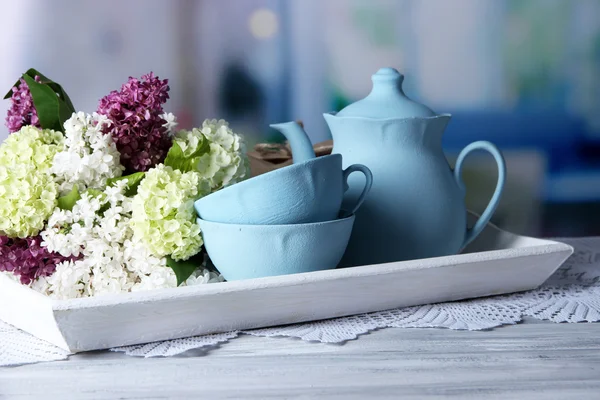 Composição com conjunto de chá e buquê de belas flores da primavera na bandeja, na mesa de madeira, no fundo brilhante — Fotografia de Stock