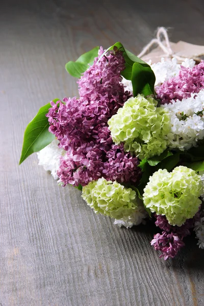 Beautiful bouquet of spring flowers on color wooden background — Stock Photo, Image