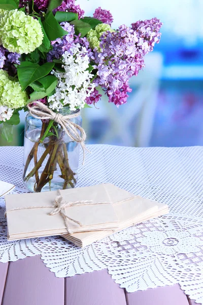 Hermosas flores de primavera en jarrón, sobre mesa de madera, sobre fondo brillante —  Fotos de Stock