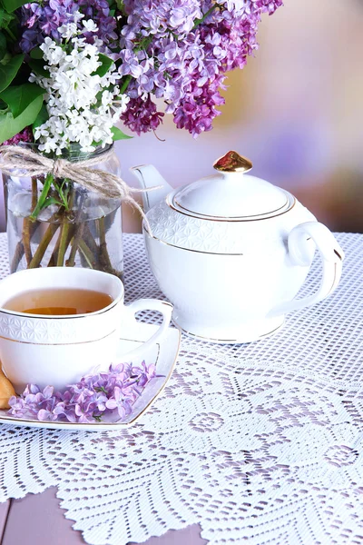 组成与茶壶、 杯子和美丽的春天鲜花插在花瓶里，木制的桌子，在明亮的背景上 — 图库照片