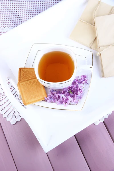 Composizione con tazza di tè, vecchie lettere su vassoio, su sfondo di legno a colori — Foto Stock