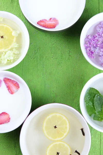 Aromatherapie-Behandlungsschale mit Blumen und parfümiertem Wasser auf Holzgrund — Stockfoto