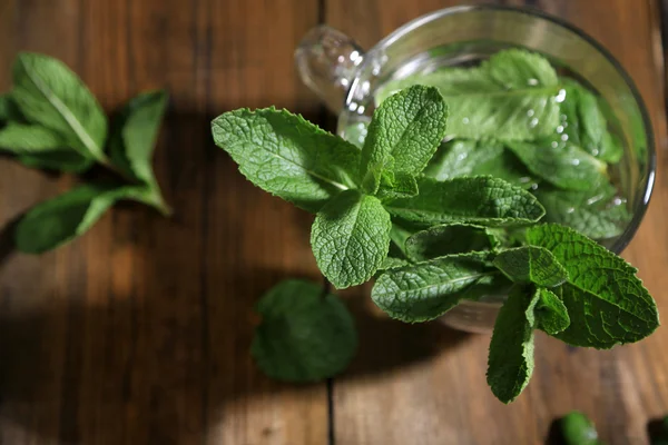 Mint in glazen pot op houten achtergrond — Stockfoto