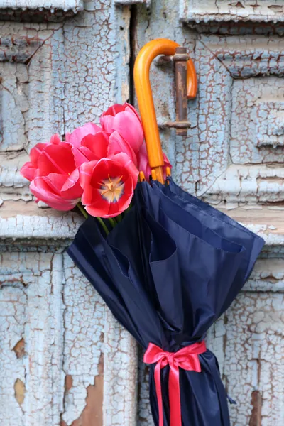 Schöne Tulpen im Sonnenschirm auf alten Holztüren — Stockfoto