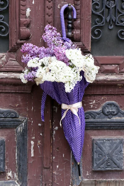 Lindas flores lilás no guarda-chuva em velhas portas de madeira — Fotografia de Stock