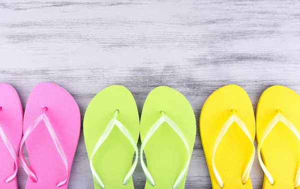 Bright flip-flops on color wooden background — Stock Photo, Image