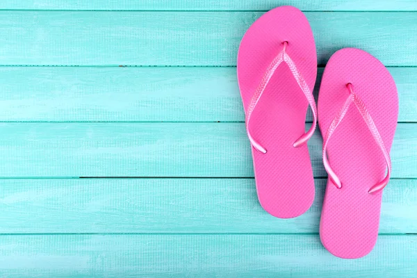 Bright flip-flops on color wooden background — Stock Photo, Image