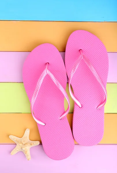 Bright flip-flops on color wooden background — Stock Photo, Image