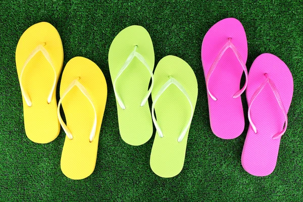 Bright flip-flops on green grass background — Stock Photo, Image