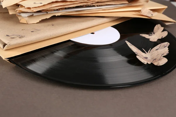 Oude vinyl record met oud papier en vlinders, op bruine achtergrond — Stockfoto